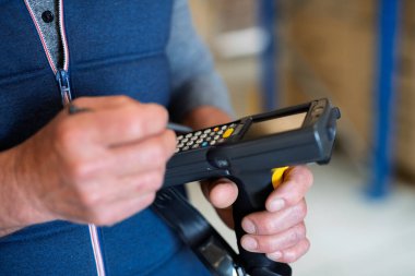 Yaşlı bir erkek depo işçisi ya da barkod tarayıcısı olan bir yönetici..