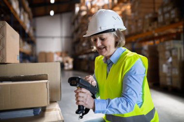 Üst düzey Depo işçisi kadın veya barkod tarayıcı ile bir mobil el bilgisayarı kullanarak Danışmanı.