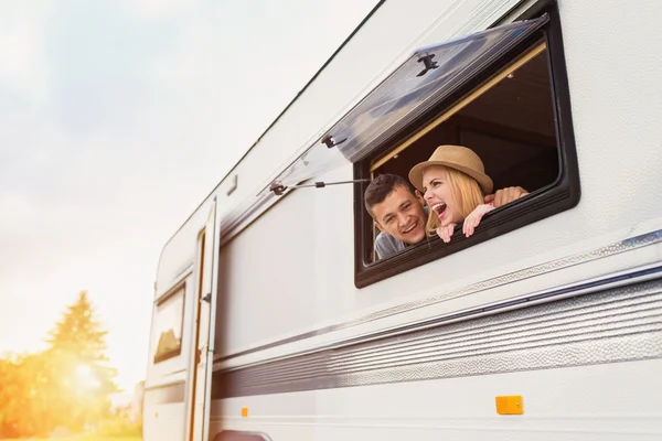 Young couple sitting in a camper van — Stock Photo, Image