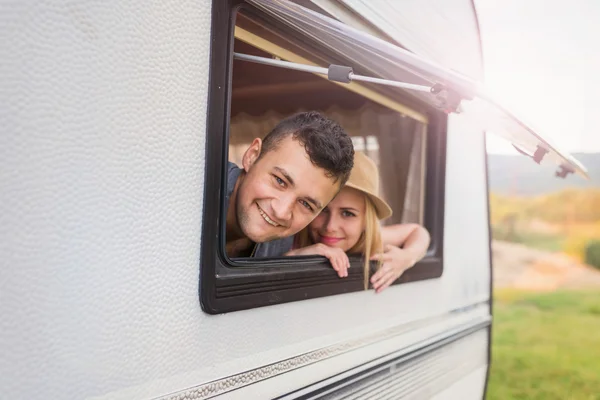 Young couple sitting in a camper van — Stock Photo, Image