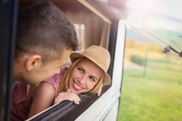 Young couple sitting in a camper van — Stock Photo, Image