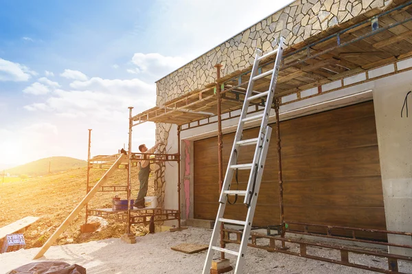 Mann legt Natursteine an eine Wand — Stockfoto