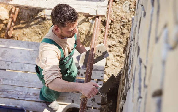 Hombre poniendo piedras naturales en una pared — Foto de Stock