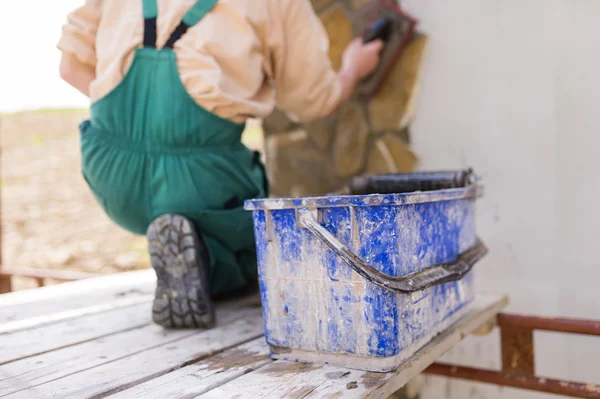 Man sätter naturliga stenar på en vägg — Stockfoto