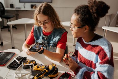 Robot projesinde çalışan lise öğrencileri, soruları cevaplamak için yapay zeka uygulamasını kullanıyorlar. STEM 'deki Kızlar.