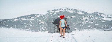 Yaşlı bir kadın kış mevsiminde dışarıda buz banyosu yapıyor. Soğuk dalış konsepti. Kopyalama alanı olan pankart.