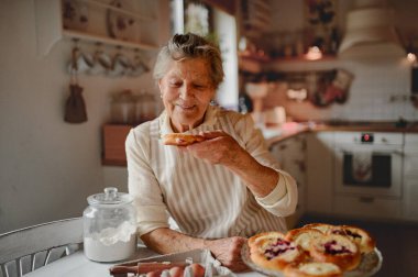 Büyükanne ev yapımı ekşi ekmek ve kolach yiyor..