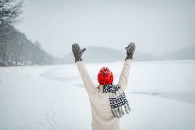 Kış manzarasında kar yağışı seyreden bir kadın. Yaşlılar için kış mevsimi.