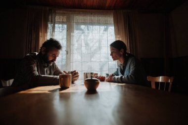 Zavallı olgun bir çiftin portresi eski evin içinde masada oturuyor. Gelecekten korkarak.