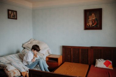 Üzgün yetim kız yatak odasında tek başına oturuyor..