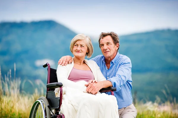 Człowiek z kobieta na wózku inwalidzkim — Zdjęcie stockowe