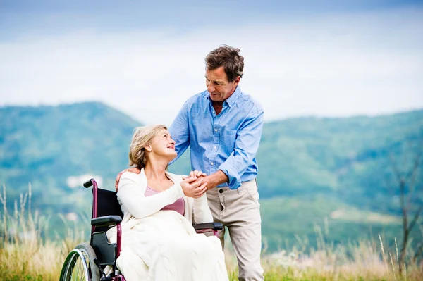 Homem com mulher em cadeira de rodas — Fotografia de Stock