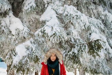 Karlı doğada kışın tadını çıkaran genç bir kadın..
