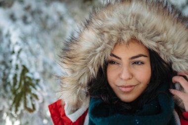 Karlı doğada kışın tadını çıkaran genç bir kadın..