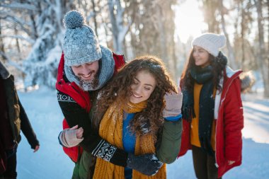 Bir grup arkadaş kışın karlı doğada eğleniyorlar..