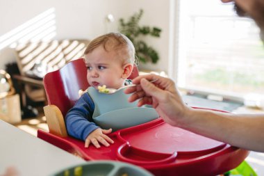 Bakıcı baba yemek saatinde bebeğini besliyor..