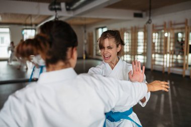 Dojo, sanat stüdyosu veya spor salonunda karate eğitimi alan güçlü kadınlar..