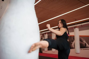 Spor salonunda boks antrenmanı yapan bir kadın. Dövüş sanatları eğitimi.