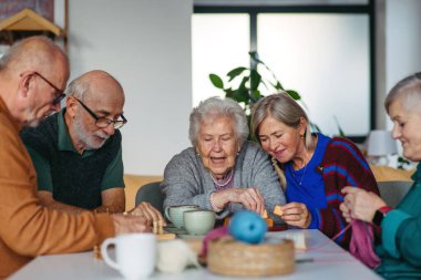 Toplum merkezinde farklı aktivitelerden zevk alan bir grup üst düzey insan, masa oyunları oynuyorlar..