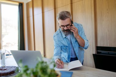 Evdeki telefon görüşmesinde not yazan adam..
