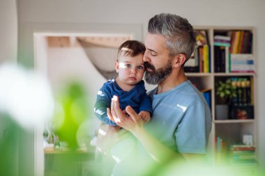 Olgun baba kucağında küçük bebeğiyle