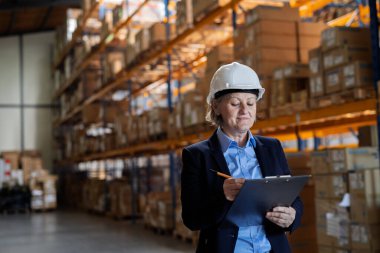 Yaşlı kadın depo müdürü ya da kasklı bir yönetici. Portre.