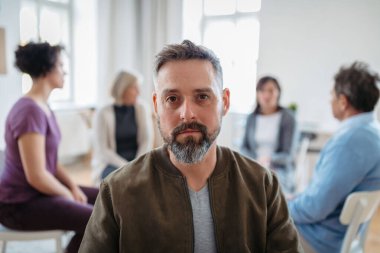 Grup terapisi sırasında olgun bir adamın portresi. Terapi seansında travma hakkında konuşmak.