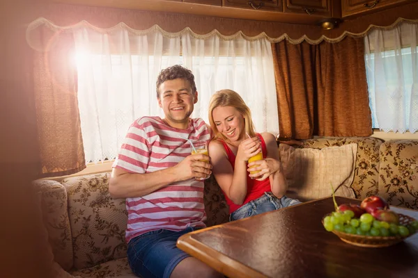 Young couple sitting in a camper van — Stock Photo, Image