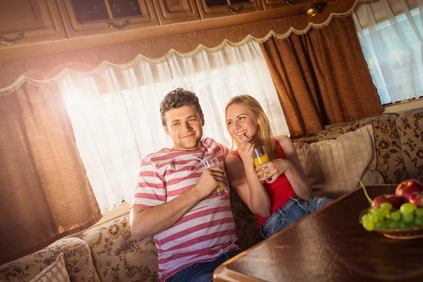 Young couple sitting in a camper van — Stock Photo, Image