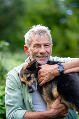 Yaşlı adam doğal ortamında köpekle kaliteli zaman geçiriyor.