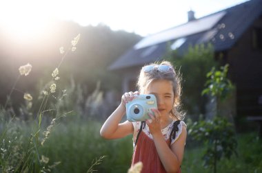 Dışarıda fotoğraf çeken küçük bir kız. Gen alfa kızı.