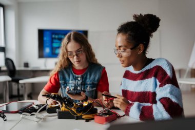 Robot projesinde çalışan lise öğrencileri, soruları cevaplamak için yapay zeka uygulamasını kullanıyorlar. STEM 'deki Kızlar.