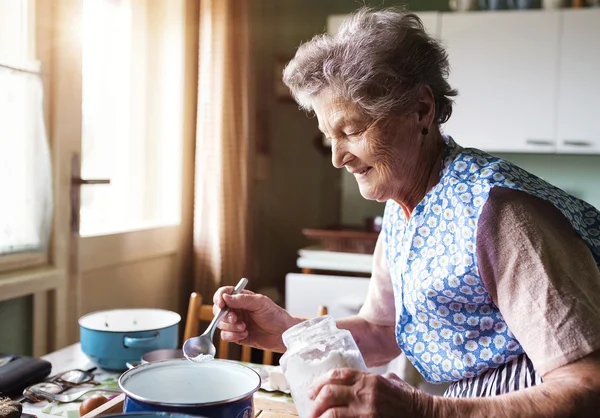 Äldre kvinna bakning — Stockfoto