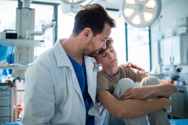 Şefkatli doktor ameliyattan önce endişeli bir genç hastayı destekliyor. Depresyondaki gençler için zihinsel sağlık değerlendirmesi.