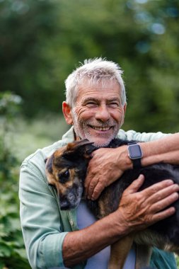 Yaşlı adam doğal ortamında köpekle kaliteli zaman geçiriyor.