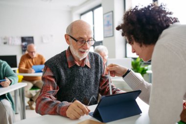Son sınıf öğrencisi, sosyal merkezde kadın öğretmen desteğiyle dijital beceriler öğreniyor..