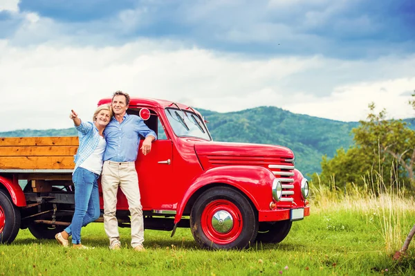 Senior paar met rode auto — Stockfoto