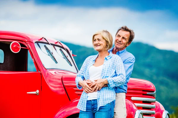 Casal sênior com carro vermelho — Fotografia de Stock