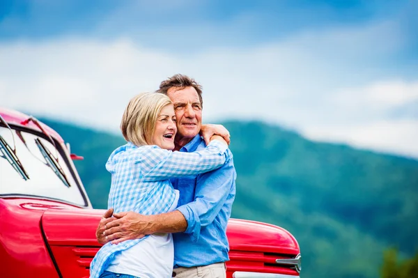 Senior paar met rode auto — Stockfoto