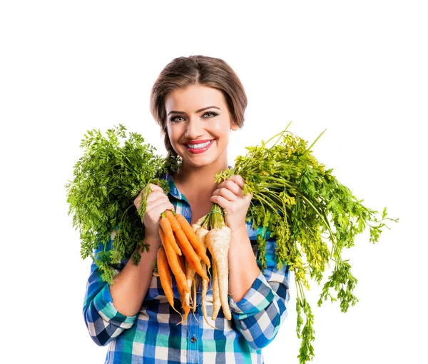 Jonge vrouw met wortelen en peterselie — Stockfoto