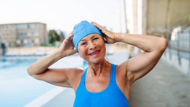 Yaşlı bayan yüzücü normal fitness yüzüşüne hazırlanıyor. Yaşlı sağlık hizmetleri.