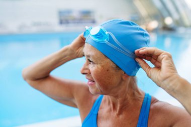 Yaşlı bayan yüzücü normal fitness yüzüşüne hazırlanıyor. Yaşlı sağlık hizmetleri.