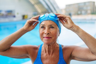 Yaşlı bayan yüzücü normal fitness yüzüşüne hazırlanıyor. Yaşlı sağlık hizmetleri.