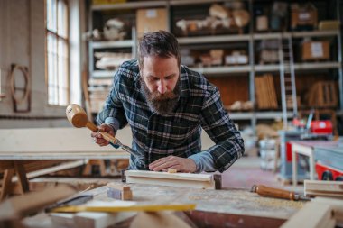 Marangoz atölyede ürünleri üzerinde çalışıyor. Küçük işletme kavramı.