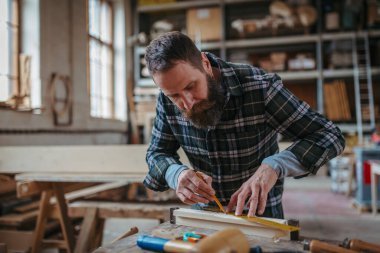 Marangoz atölyede ürünleri üzerinde çalışıyor. Küçük işletme kavramı.