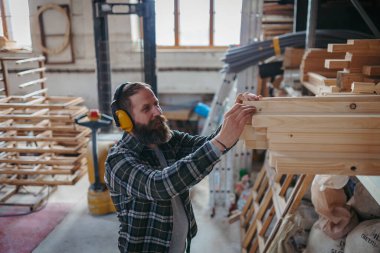Marangoz mobilyaları yapmadan önce ahşap parçaları hazırlıyor. Küçük işletme kavramı.