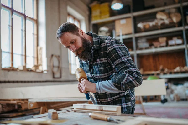 Marangoz atölyede ürünleri üzerinde çalışıyor. Küçük işletme kavramı.