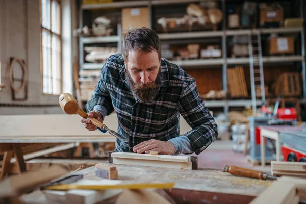 Marangoz atölyede ürünleri üzerinde çalışıyor. Küçük işletme kavramı.