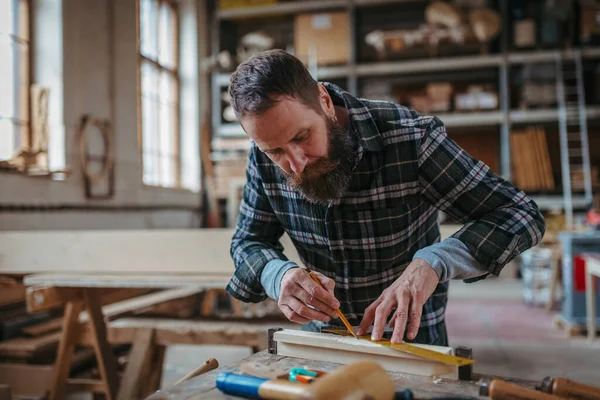 Marangoz atölyede ürünleri üzerinde çalışıyor. Küçük işletme kavramı.