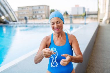 Yaşlı kadın havuzda yüzmeye hazırlanıyor..